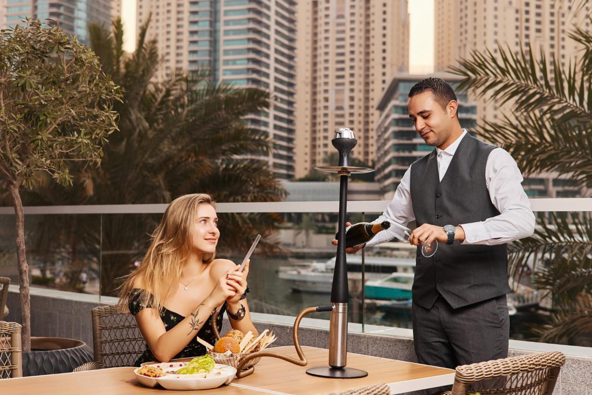 คราวน์ พลาซา ดูไบ มารีนา Hotel ภายนอก รูปภาพ A waiter serving a guest